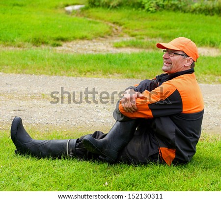 Tired after a hard work man sitting on the ground
