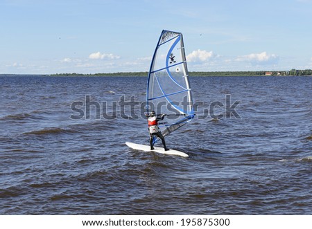 OULU, FINLAND - JULY 17, 2012:Windsurfing is surface water sport that combines elements of surfing and sailing. It consists of board usually 2 to 3 metres long, with volume of about 60 to 250 liters