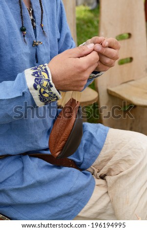 Medieval leatherworker makes leather purse