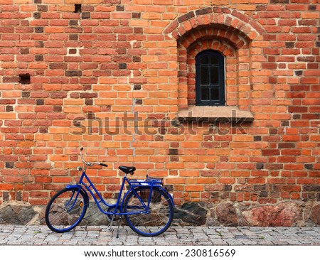 Old bicycle near red brick wall