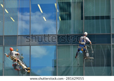 MOSCOW, RUSSIA - MAY 25, 2015: Group of workers cleaning windows service of  modern office building in Moscow International Business Center