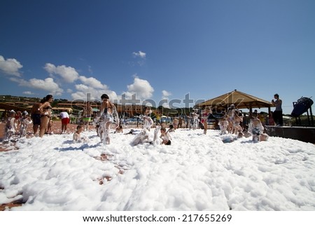 SARDINIA, ITALY - JULY 5, 2014. Foam Party on a resort in Sardinia, Italy. Group of people enjoying in drinking, dancing and music.