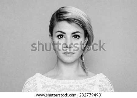 serious, open minded young woman, face with freckles