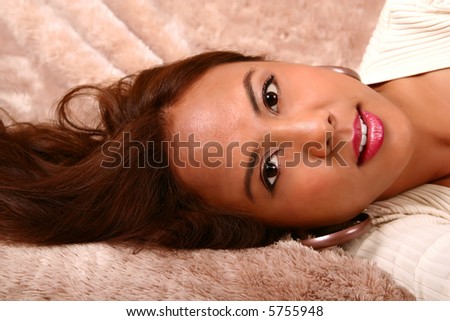 shot of woman laying sideway on her bed, waiting for somebody. skin was smoothen no noise reduction used