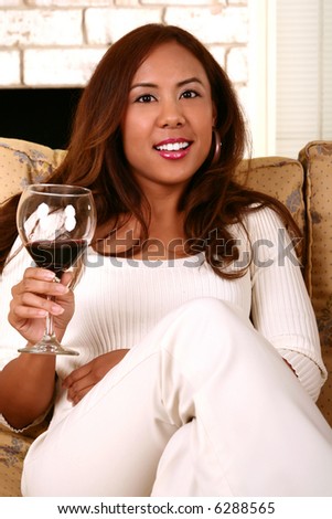 casual shot of woman holding wine. skin was smoothen no noise reduction used