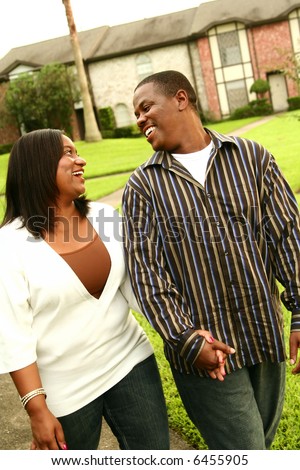 african american couple walking on outdoor with house background