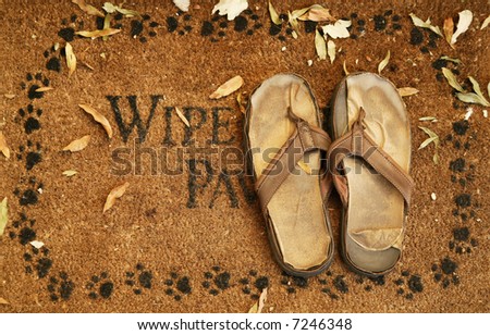 an outdoor mat covered by leaves represent fall and worn off home sandal