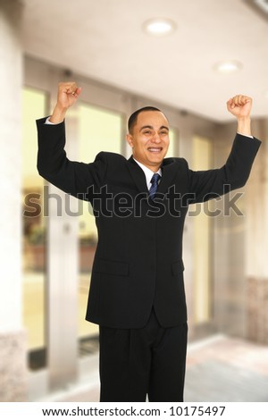 a man raised his man with joyful expression when coming out from office building because he just got a job