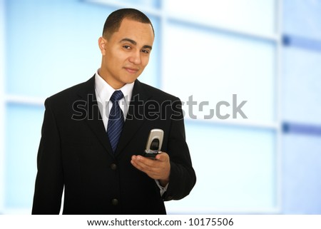 business man holding phone and looking at camera in his office hallway