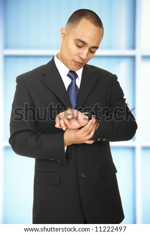 a man in business suit checking his watch in his office