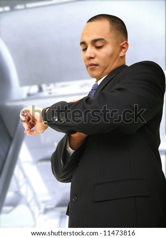 a business man looking at his watch outdoor in contemporary business building