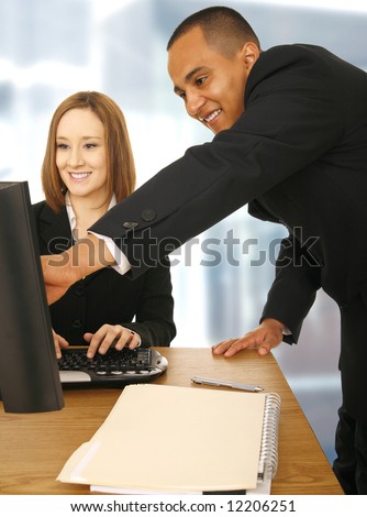 business man showing and pointing at screen while his coworker looking at the computer screen and smile. concept for mentor, supervisor, office related, and team work