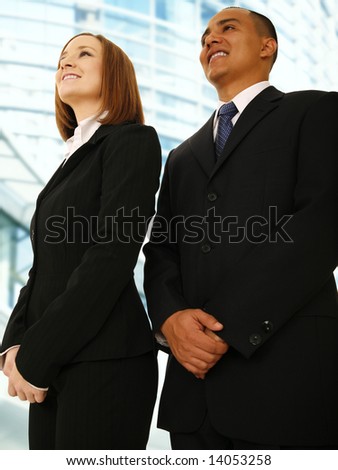 business man and business woman standing and looking up smiling. concept for successful team work