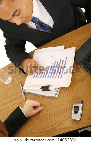 shot of business man pointing at raising sales chart, another hand of woman on the table. concept for finance, business discussion, or team work