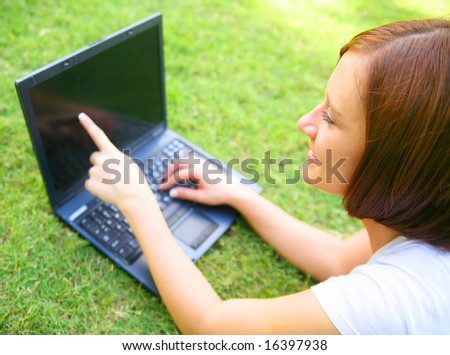 beautiful caucasian woman with happy expression using computer outdoor