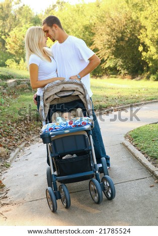 beautiful young caucasian family on evening walk in park