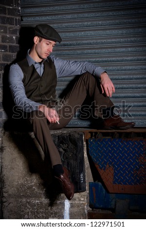 Young male relaxing in flat cap smoking