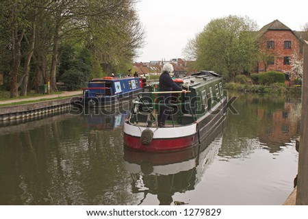 Green narrow boat traveling on canal