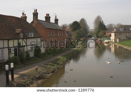 Cottages beside river with ducks& boats