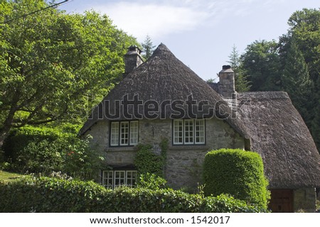thatch & stone cottage in rural wooded landscape