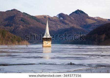 Abandoned church in a mud lake. Natural mining disaster with water pollution