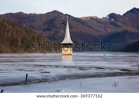 Abandoned church in a mud lake. Natural mining disaster with water pollution