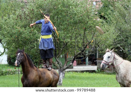 VALCELE, ROMANIA - AUGUST 11: An unidentified Hungarian  rider demonstrates archery on horseback at the yearly organized \