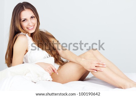 Studio portrait of young beautiful woman on bed