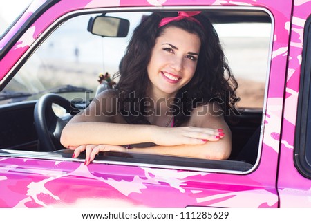 beautiful woman sitting in the pink car
