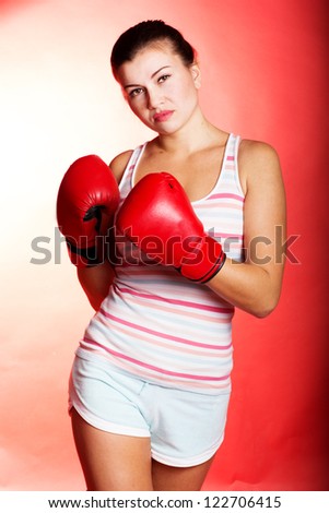 Attractive young woman wearing red boxing gloves