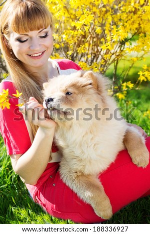 Pretty girl with her hairy dog on the nature, spring time