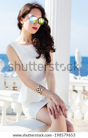 Beautiful young sexy fashion model posing near the sea