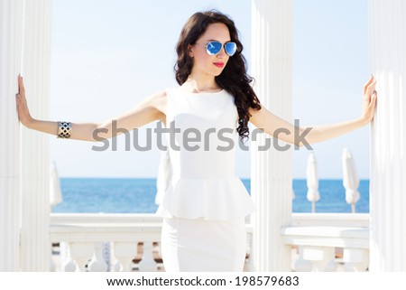 Beautiful young sexy fashion model wearing dress posing near the sea