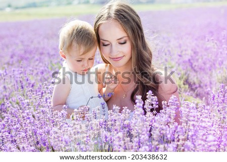 Mother and daughter playing in lavender field on beautiful summer day Mother and daughter playing in lavender field on beautiful summer day