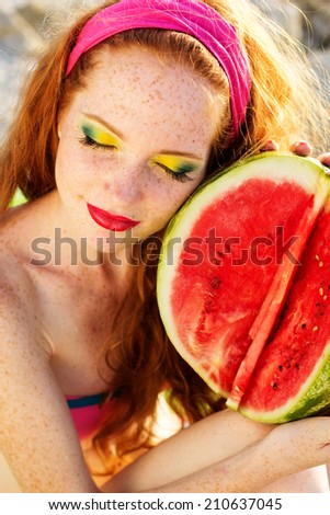 Smiling girl with freckles holding watermelon