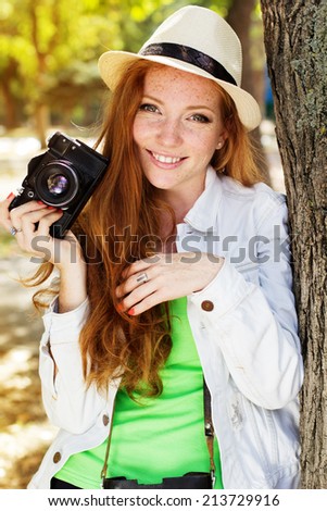 Nice red-haired girl photographer at work