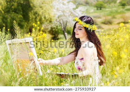 Young female artist is wearing wreath of yellow flowers is create picture of an floral landscape, spring time