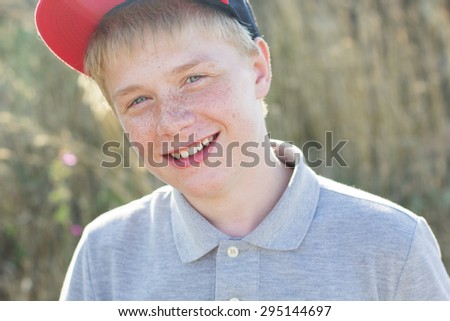 Portrait of cute boy with freckles is wearing cap, summer time