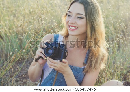 Portrait of tourist smiling girl making photos of the nature by old camera summer time