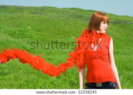The red-haired girl  in a red scarf from feathers