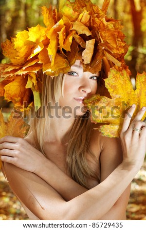 Nude girl  in the autumn forest with the maple leaves