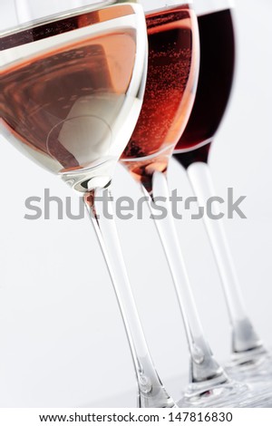 white wine,rose wine, red wine , 3 glasses against white background
