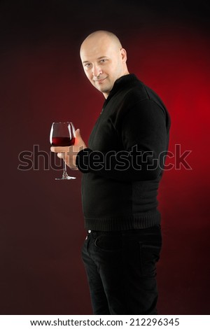 38 years old man holding glass of Rose wine and wearing  black jeans and jacket bold head
