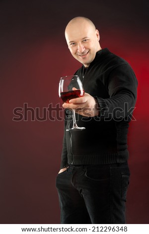 38 years old man holding glass of Rose wine and wearing  black jeans and jacket bold head