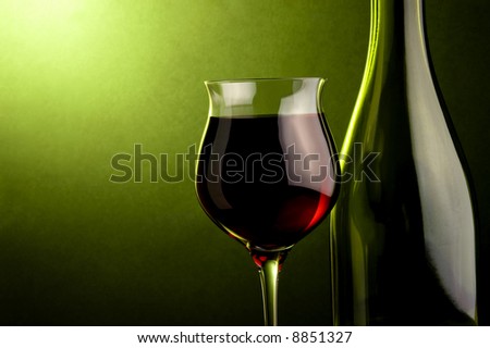 a glass and a bottle with red wine details