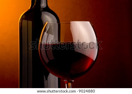 a glass and a bottle of red wine details