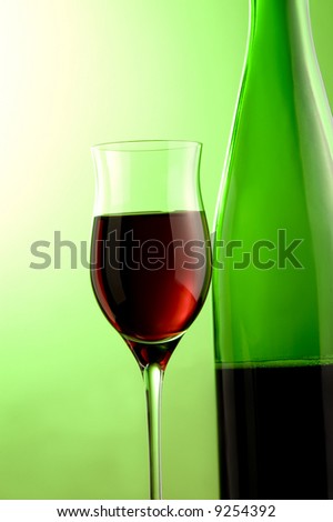 a glass and a bottle with red wine details