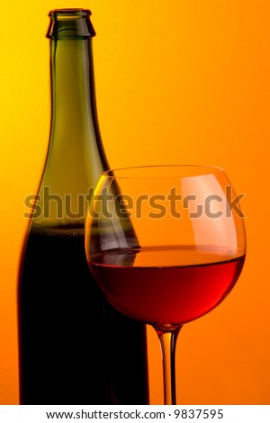 a glass and a bottle  of red wine details