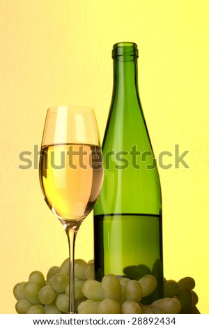 a glass of white wine grape and bottle