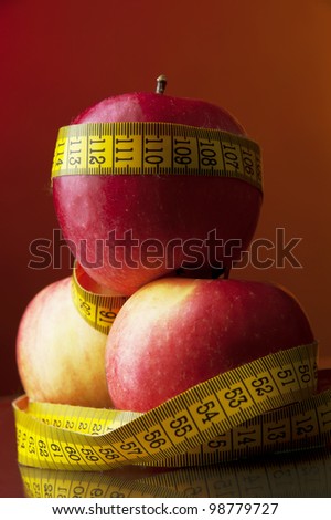 apple and meter tape at color background